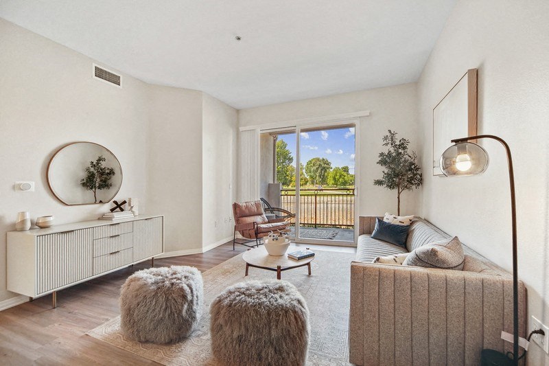 a living room with a sliding glass door to a balcony