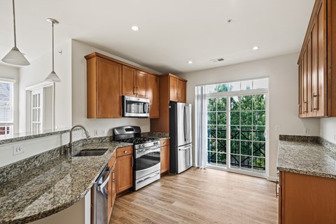 A kitchen with granite countertops and wooden cabinets.
