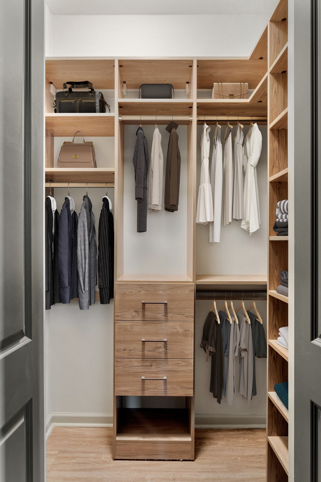 a walk in wardrobe with wooden shelves and drawers