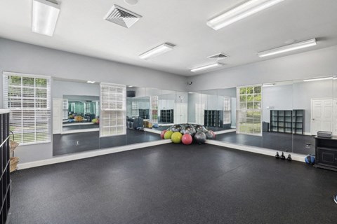 a workout room in a gym with weights on the floor