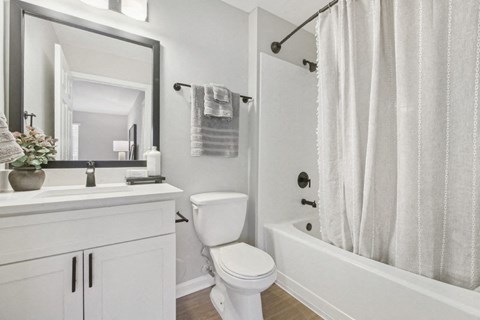 A white bathroom with a toilet, sink, and bathtub.