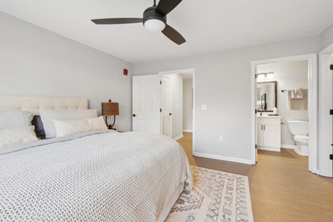 A bedroom with a large bed and a ceiling fan.