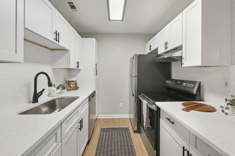 A kitchen with white cabinets and a stainless steel oven.