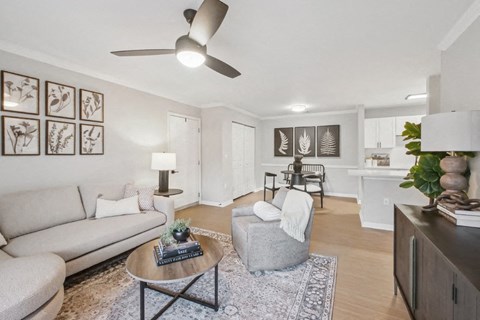 A living room with a grey couch, a coffee table, and a ceiling fan.