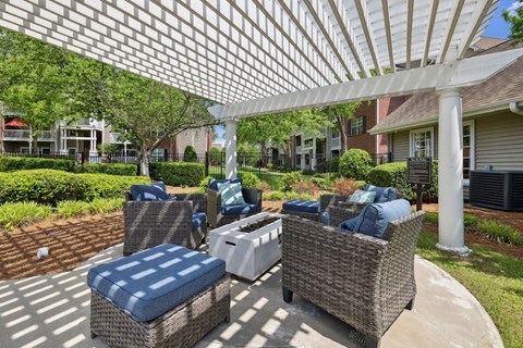 a covered patio with wicker furniture and a white pergola