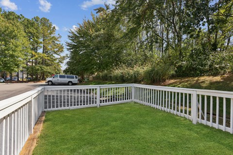 A white fence encloses a green lawn.