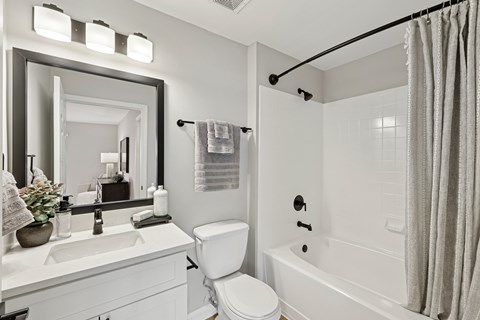 A white bathroom with a sink, toilet, and bathtub.