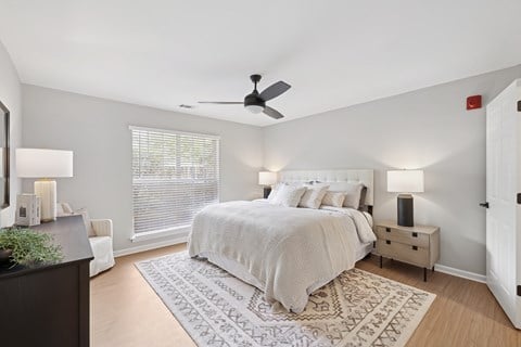 A bedroom with a large bed and a ceiling fan.