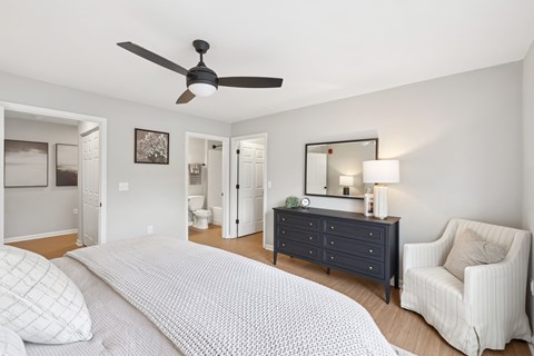 A bedroom with a bed, dresser, and chair.