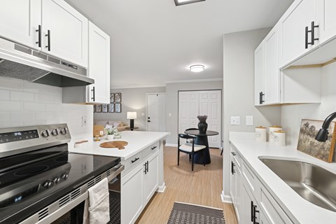 A kitchen with white cabinets and a black stove top oven.