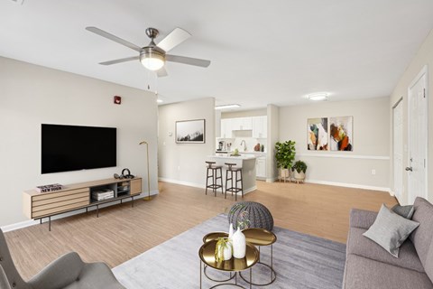 a living room with a ceiling fan and a television