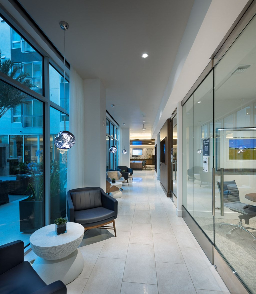a long corridor with chairs and a table in a hotel lobby