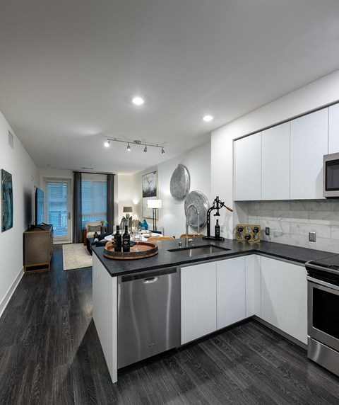 a kitchen with white cabinets and a black counter top