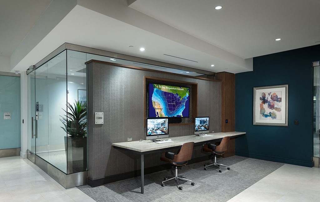a large desk with three monitors in a room with a shower