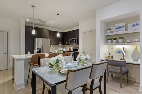 a dining room and kitchen area with a table and chairs