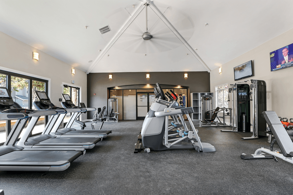 A gym with treadmills, weights, and exercise equipment.