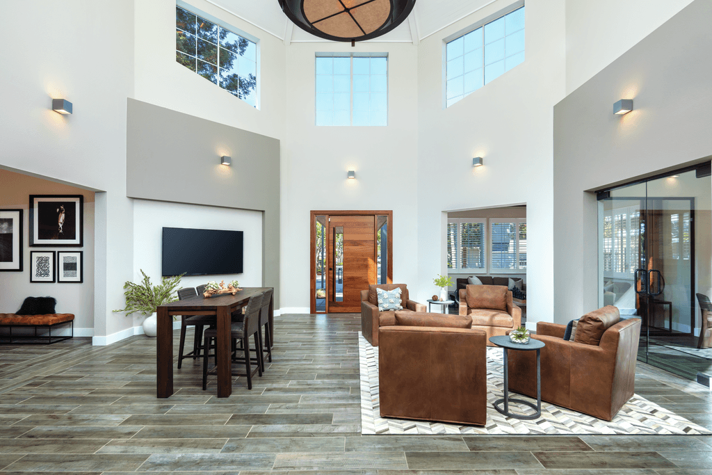 A living room with a brown sofa and a wooden table.