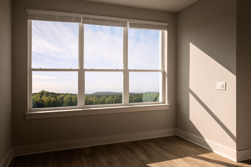 a room with a large window and a view of trees