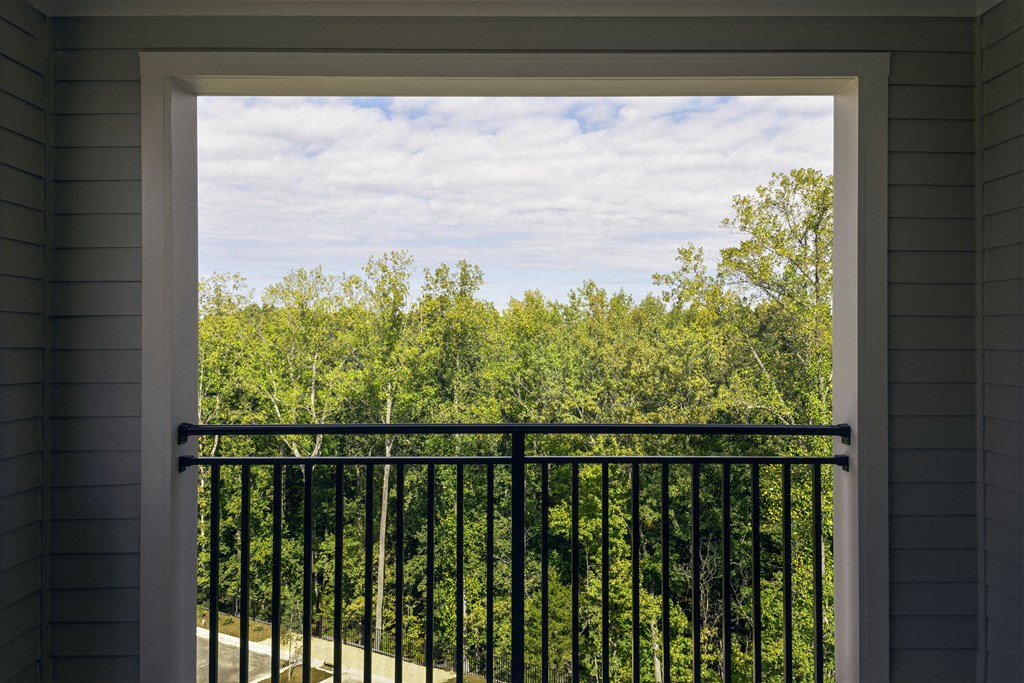 a view of the woods from a balcony with a balcony guard rail