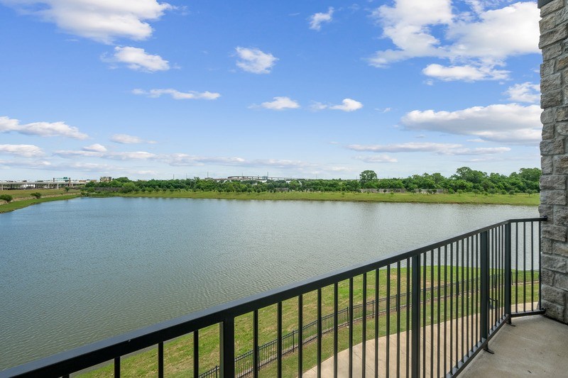 A balcony overlooks a calm lake with a clear blue sky above.