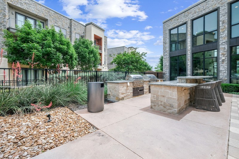A modern building with a stone facade and a metal fence.
