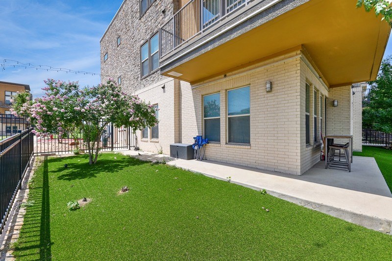 A small house with a yellow roof and a small garden in front.