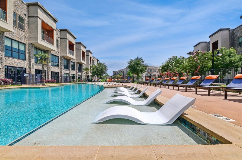 A pool with a diving board in front of a building.