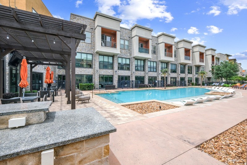 A large swimming pool with chairs and umbrellas.