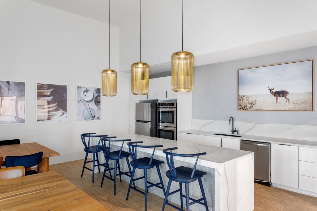 a long kitchen island with blue chairs around it