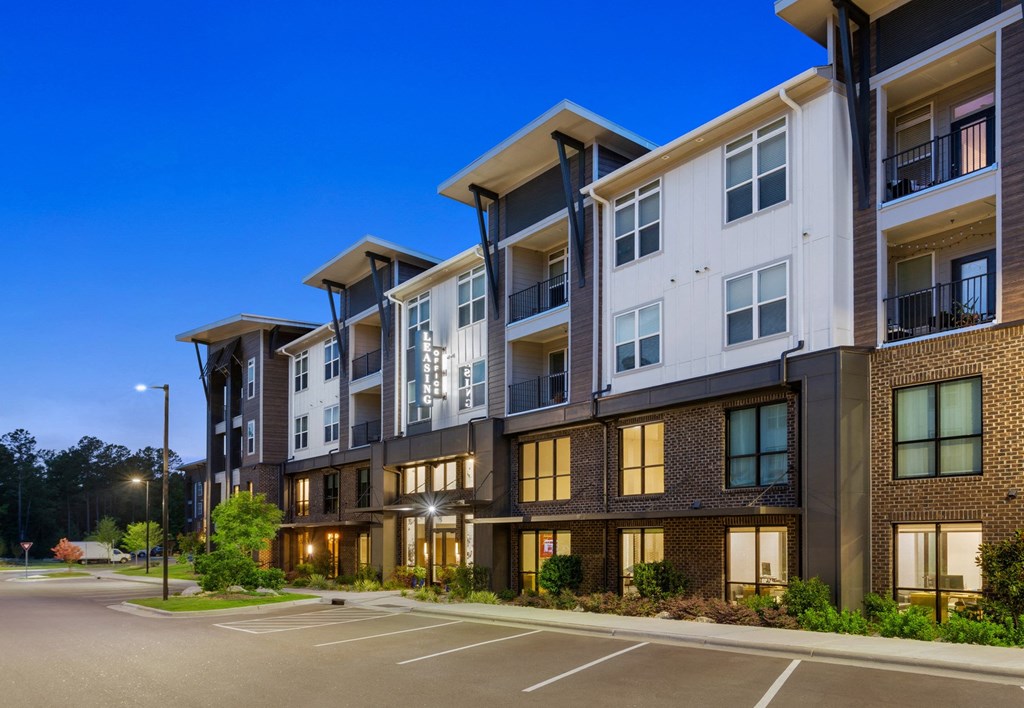 apartment building with a parking lot in front of it