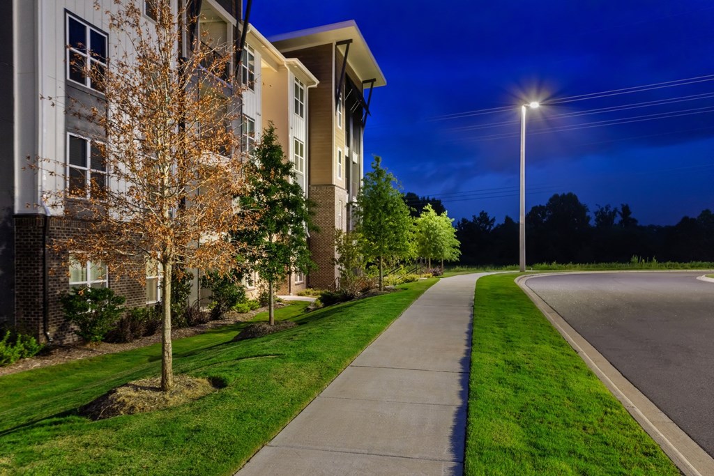 a path with grass around it and a building next to it