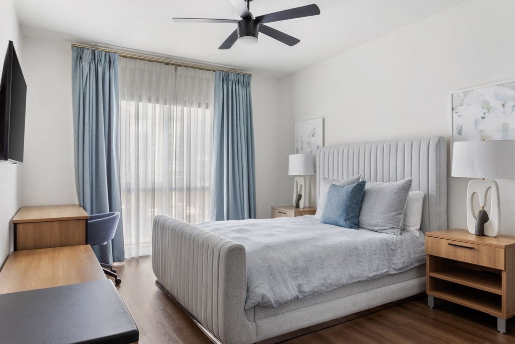 a bedroom with a bed and a ceiling fan