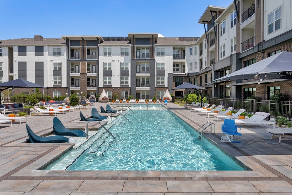 a large pool surrounded by an apartment complex