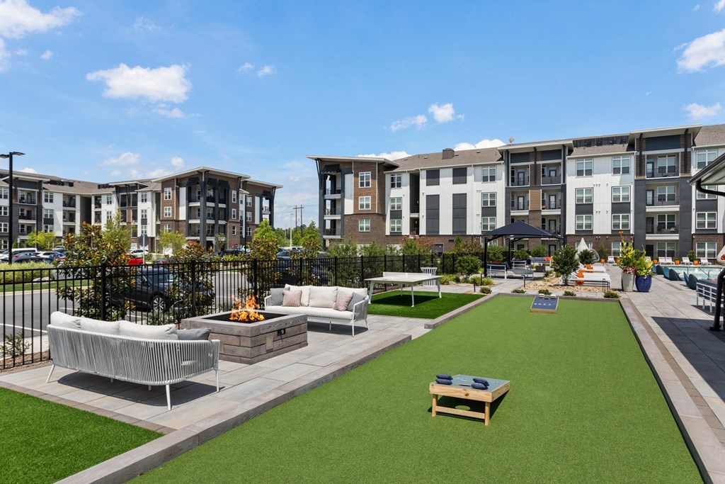 A fire pit is in the middle of a grassy area.
