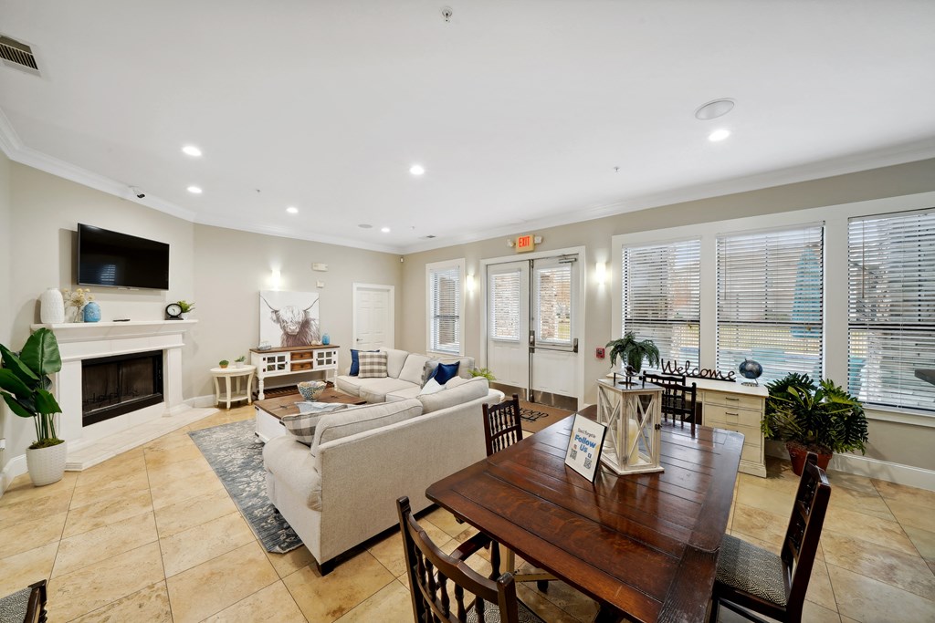 a room with a table and chairs around it and a couch in the middle