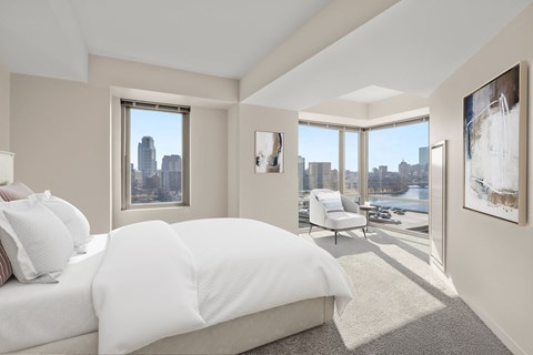 a white bedroom with a large bed and a window