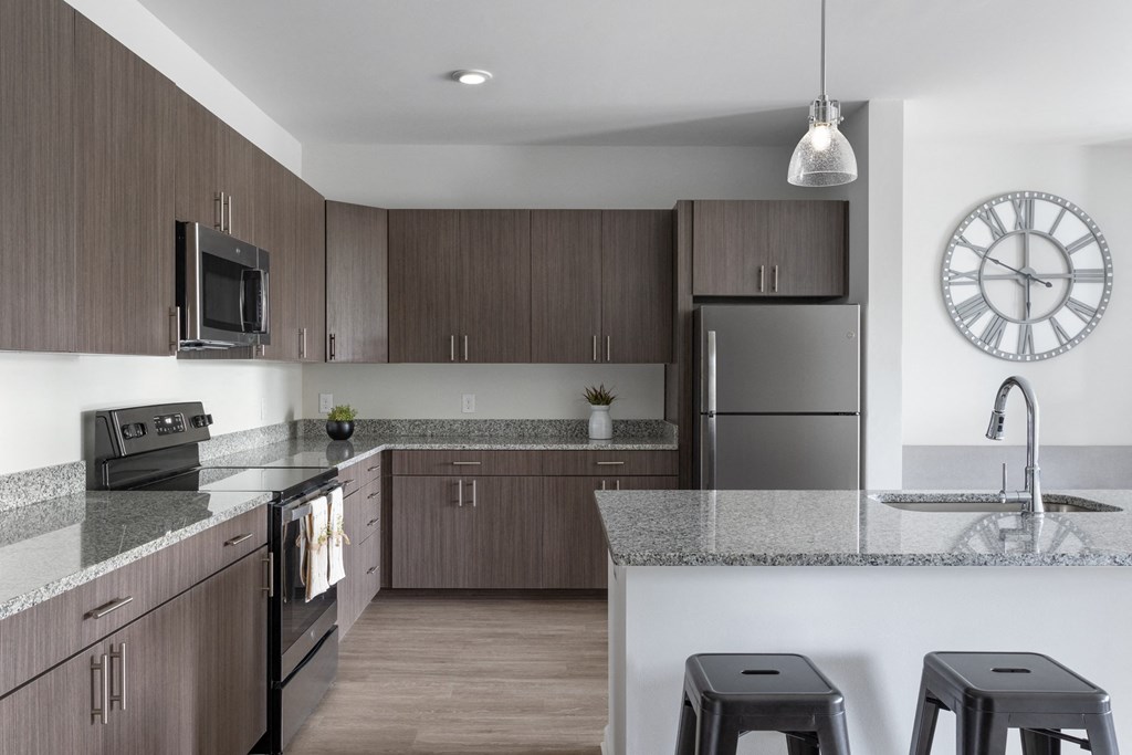 interior model home kitchen with garnite countertops and stainless steel appliances