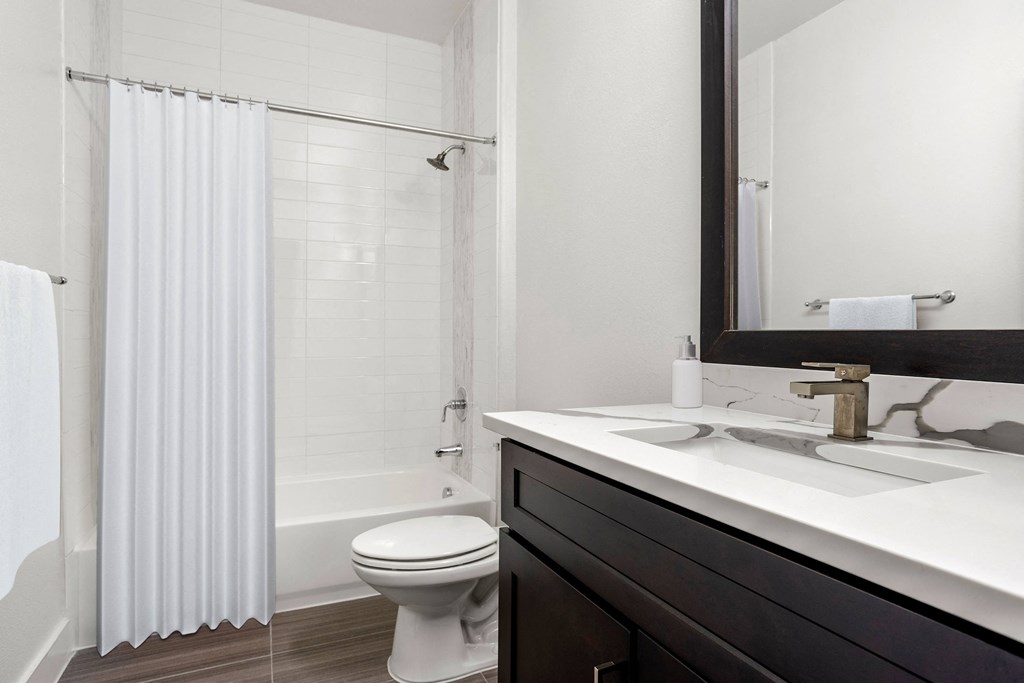 a bathroom with a shower and a sink and a toilet