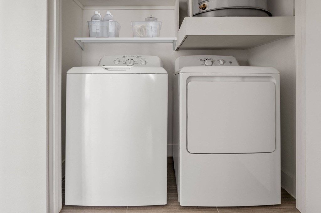 a white washer and dryer in a small laundry room