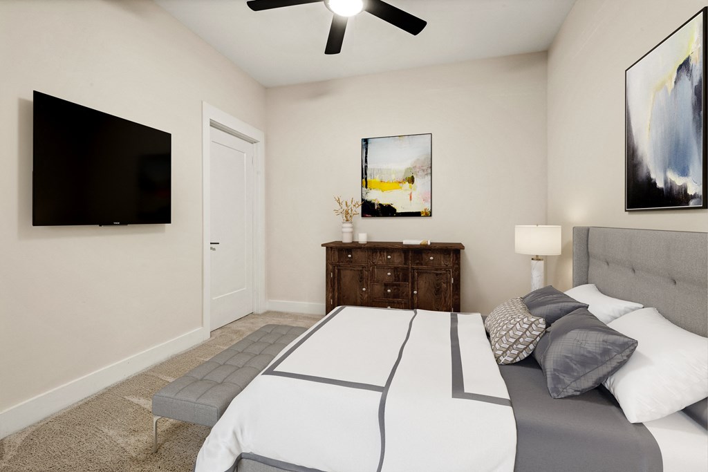 a bedroom with a large bed and a ceiling fan