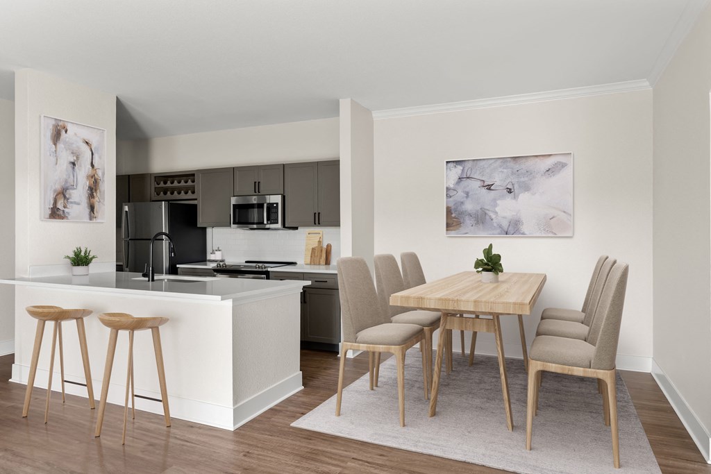 an open kitchen and dining area with a wooden table and chairs and a white counter