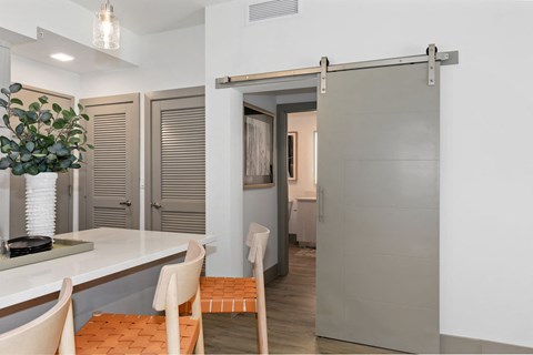 A kitchen with a white counter and chairs.