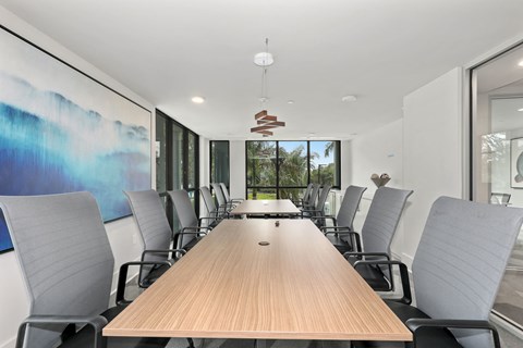 A conference room with a long table and chairs.