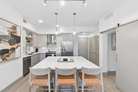 A modern kitchen with a white table and chairs.