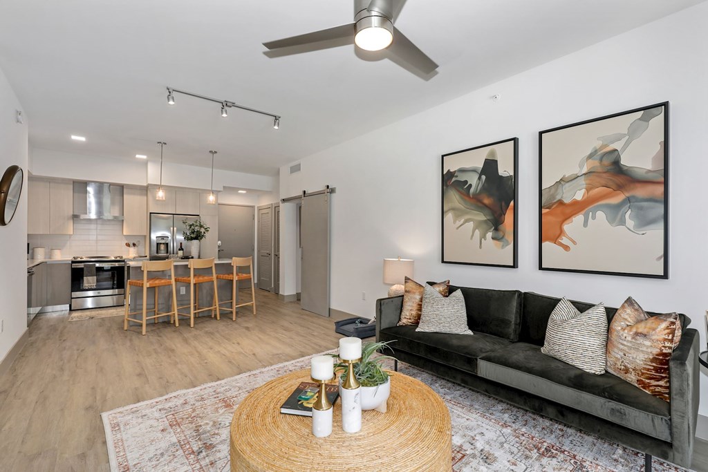 A living room with a couch, a table, and two paintings on the wall.