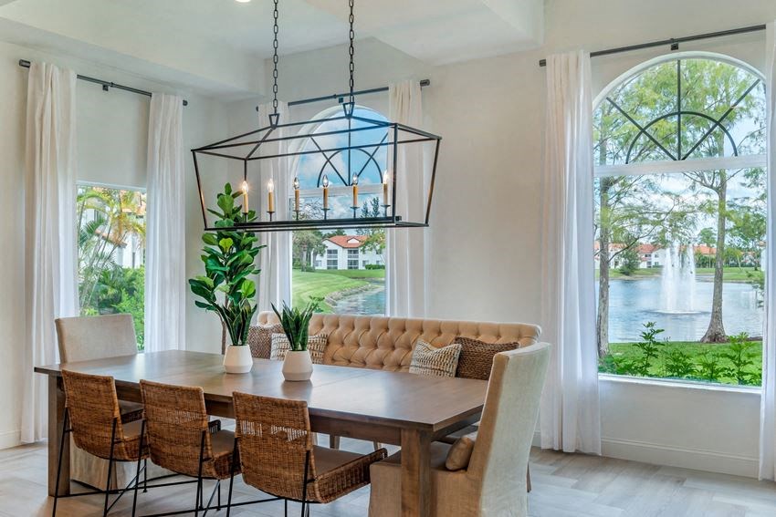 a dining room with a table and chairs and a large window
