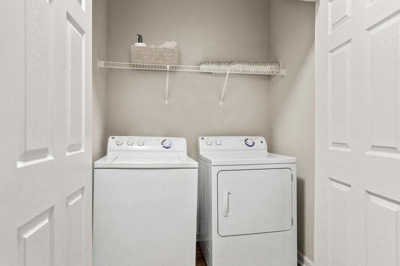 a small laundry room with two washers and a dryer