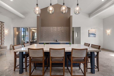 A modern dining room with a large table and chairs.