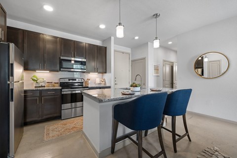 A modern kitchen with dark brown cabinets and a central island.