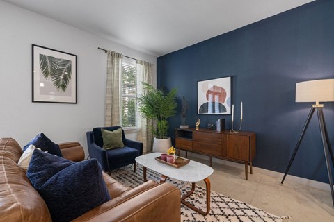 A living room with a brown leather couch and a white coffee table.